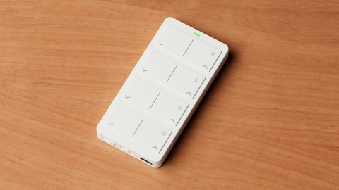 White mini remote close up on a wooden surface